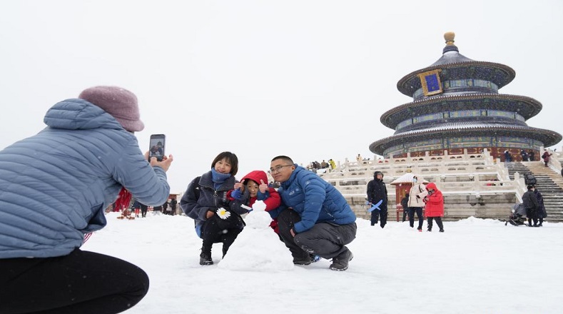 A medida que la ventisca se alejó de Beijing y el cielo se despejó, los encantos del parque Tiantan sedujeron a más de una familia a un paseo en medio de la nieve.