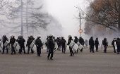 Policías kazajos hacen frente a los manifestantes después de atacar una sede gubernamental en la ciudad de Almaty.