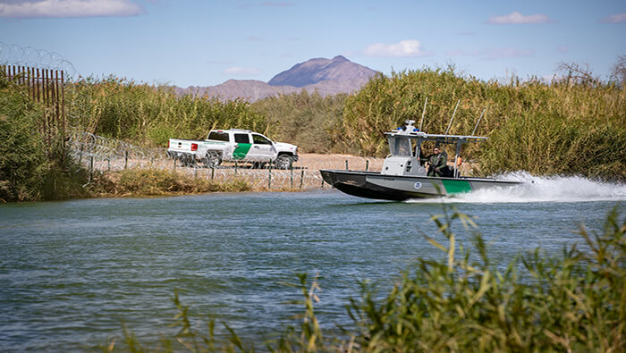Agentes fronterizos estadounidenses buscan a migrantes que intentan llegar a EE.UU. cruzando el Río Bravo desde México.