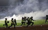 Policías tratan de contralar a la multitud tras el enfrentamiento entre hinchas y jugadores del equipo Arema.