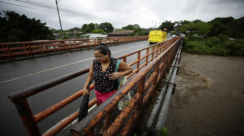 El paso de Julia por El Salvador ha dejado un territorio prácticamente inundado, puentes destruidos, deslaves y un número aún no precisado de fallecidos.