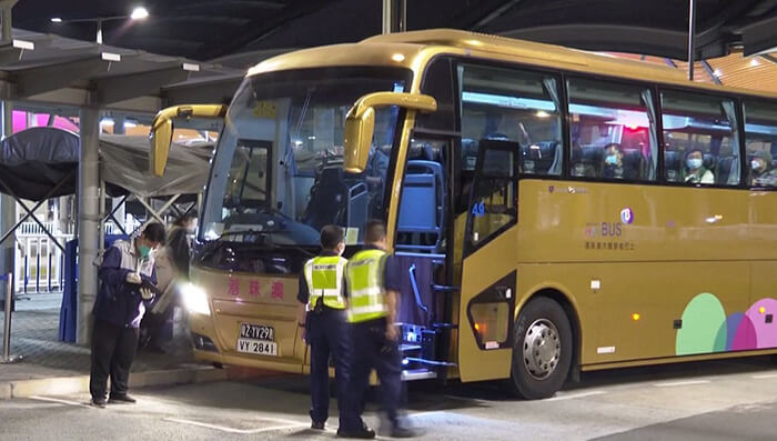 Funcionarios migratorios chinos revisan un autobús con turistas.