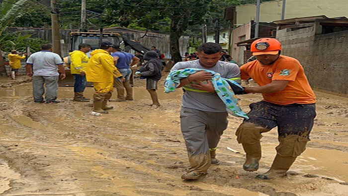 Funcionarios de Defensa Civil ayudan a rescatar a víctimas de las inundaciones en el estado de Sao Paulo.
