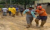 Funcionarios de Defensa Civil ayudan a rescatar a víctimas de las inundaciones en el estado de Sao Paulo.