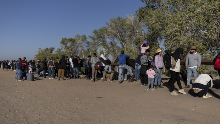 Migrantes esperan a ser procesados por agentes de la Patrulla Fronteriza de EE.UU. tras cruzar de manera irregular en Yuma, Arizona.