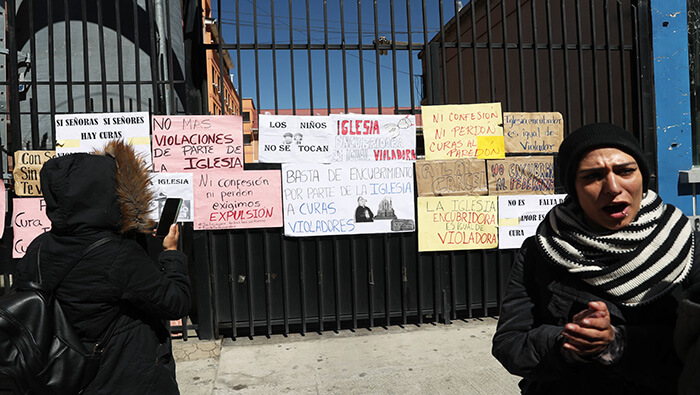 Varias personas protestan en contra de la Iglesia católica pegando carteles en las puertas del seminario San Jerónimo, en la capital boliviana.