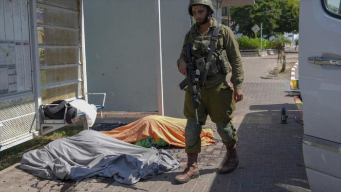 Un soldado israelí junto a los cuerpos de israelíes muertos por ataques con cohetes lanzados desde la Franja de Gaza, en la ciudad de Sderot.
