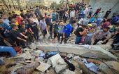 Civiles palestinos colaboran en la búsqueda de cadáveres y sobrevivientes que permanecen bajos los escombros de edificios destruidos en la Franja de Gaza.