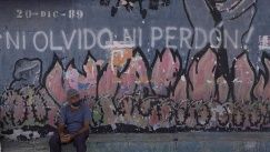 Un residente descansa frente a un mural alusivo a la invasión de Estados Unidos a Panamá de 1989 en el barrio de El Chorrillo, uno de los principales puntos destruidos durante la invasión, en la Ciudad de Panamá, la capital panameña, el 25 de marzo de 2022.